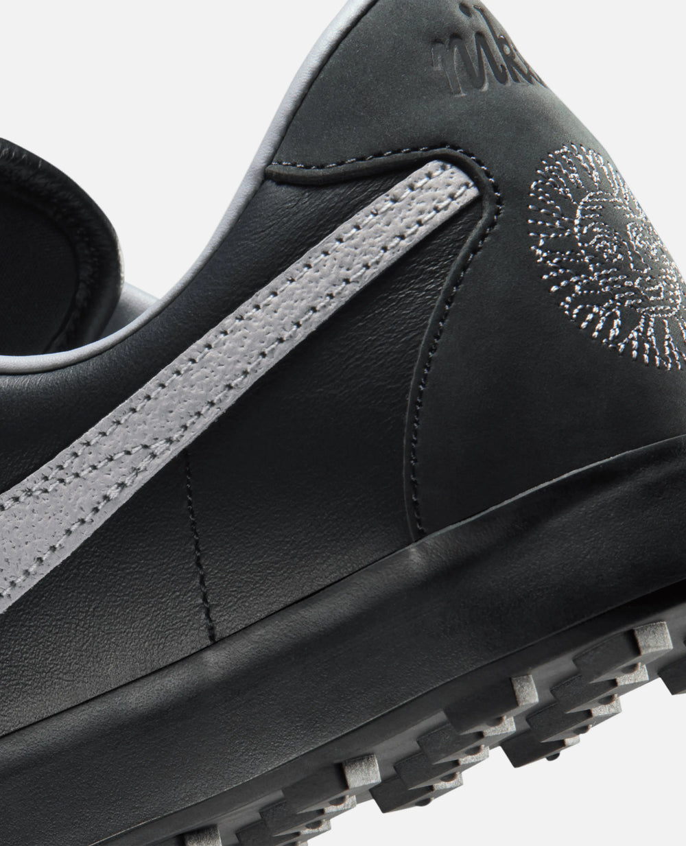 Heel and waffle sole detail of the Nike Astrograbber sneaker in Off Noir black leather and Cement Grey.
